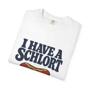 A folded white t-shirt with a dark navy blue graphic text reading 'I HAVE A SCHLORT' and a partial hot dog illustration below, shown on a clean white background.