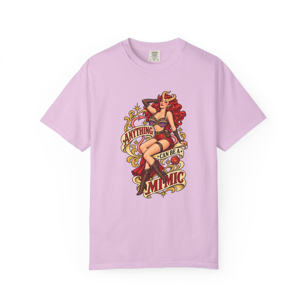 A light purple short-sleeve crewneck t-shirt featuring a vintage-style pin-up graphic on the front. The graphic depicts a woman with red hair in a black and red outfit, with retro text reading 'ANYTHING CAN BE A MIMIC' in red, yellow, and black.