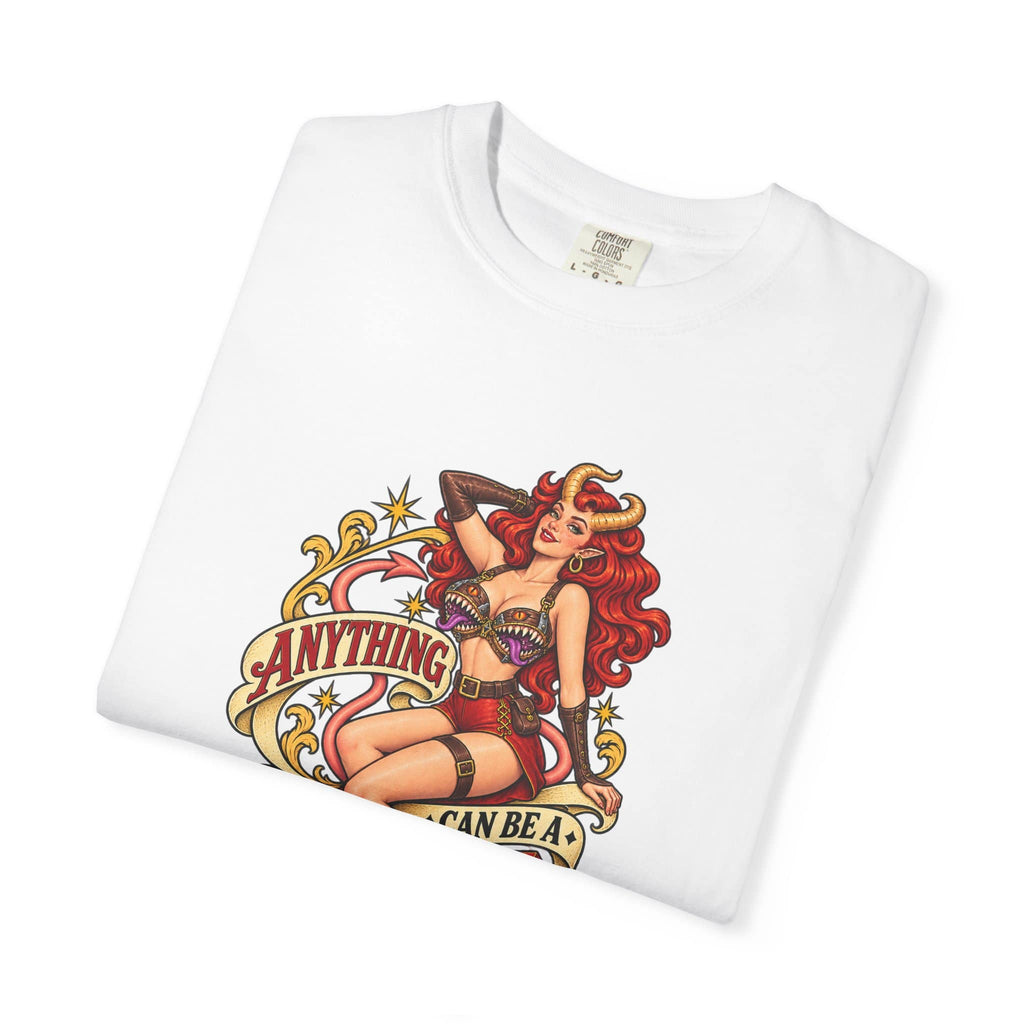 A folded white crewneck t-shirt featuring a colorful graphic print of a pin-up style illustration with the text 'ANYTHING I CAN BE A MIMIC'.