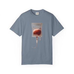 A blue-grey t-shirt displayed flat, featuring a surreal graphic of a brain suspended in an IV drip bag