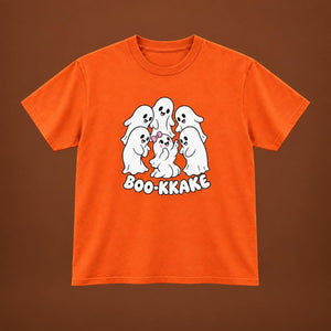An orange short-sleeve t-shirt with a cartoon graphic of five white ghosts and the text 'BOO-KKAKE' printed on the front, displayed against a solid brown background.