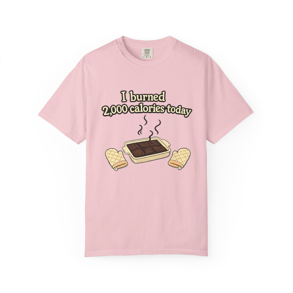 A light pink garment-dyed t-shirt featuring a cartoon of smoking brownies and the joke "I burned 2,000 calories today."