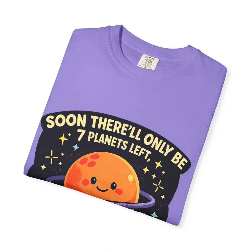 Neatly folded purple t-shirt showing a cute orange planet graphic and a dirty astronomy joke.