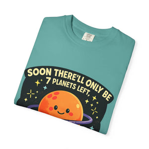 Neatly folded teal t-shirt showing a cute orange planet graphic and a dirty astronomy joke.