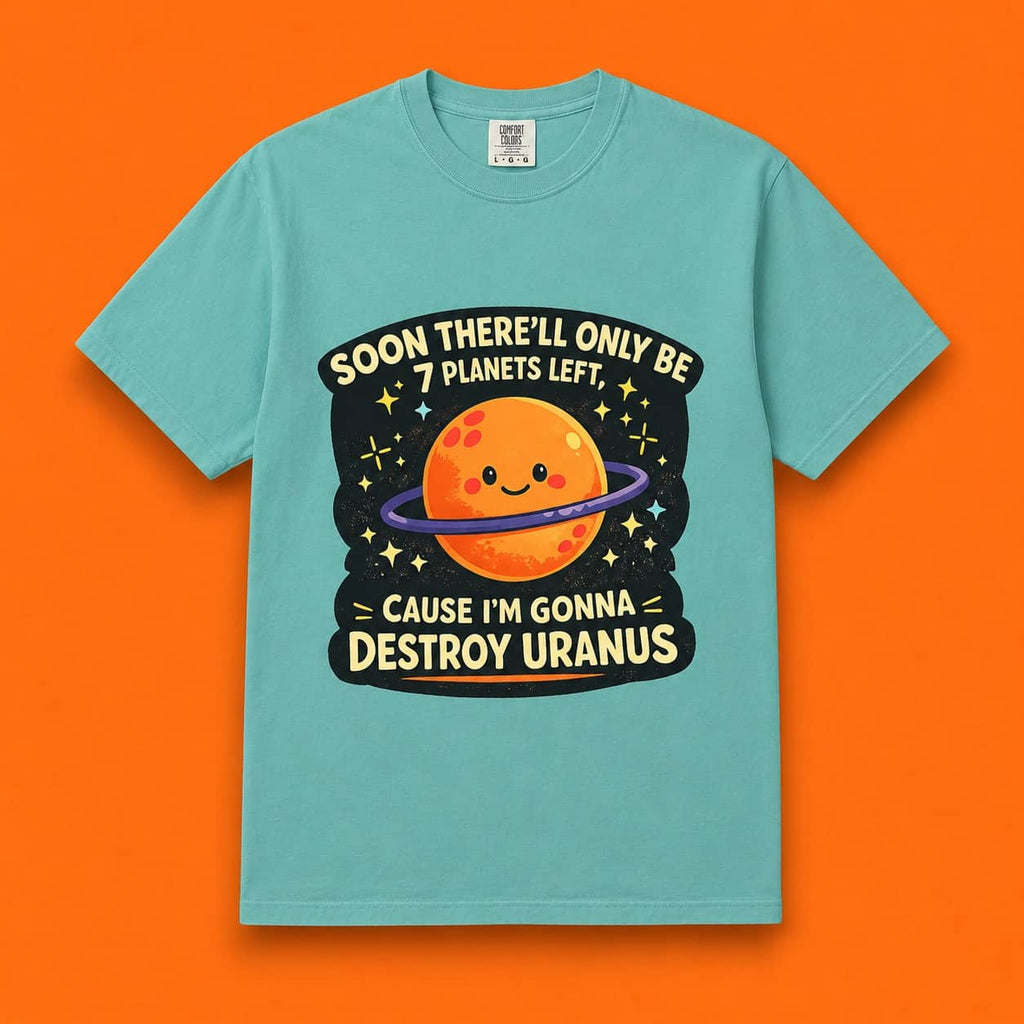 Flat lay of a teal Destroy Uranus funny meme t-shirt on a bright orange background.