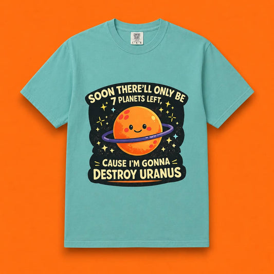 Male model standing outdoors in front of a space-themed mural wearing a teal Comfort Colors t-shirt with a cute planet graphic that says Soon there'll only be 7 planets left cause I'm gonna destroy Uranus.