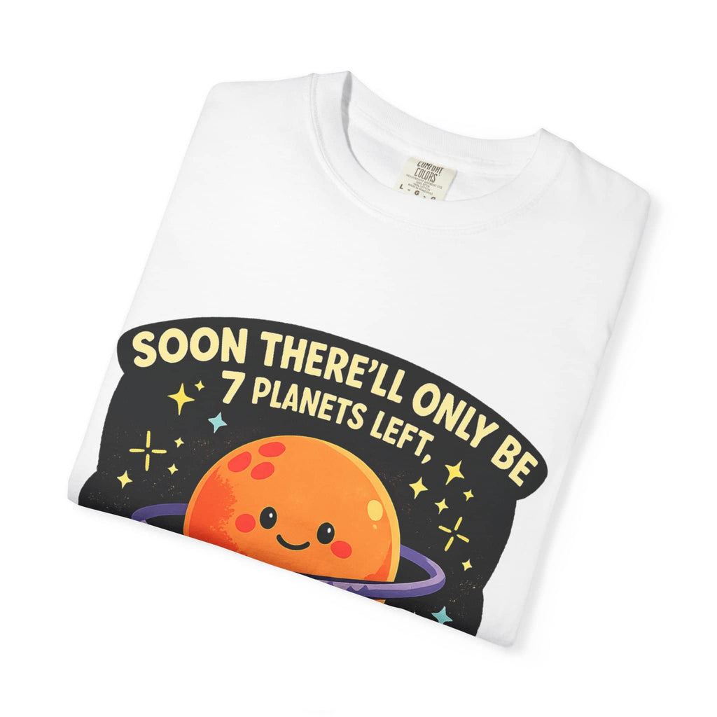 Neatly folded white t-shirt showing a cute orange planet graphic and a dirty astronomy joke.