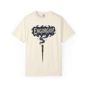 Flat lay of a cream-colored vintage t-shirt featuring a magic wand and swirling Engorgio spell text.