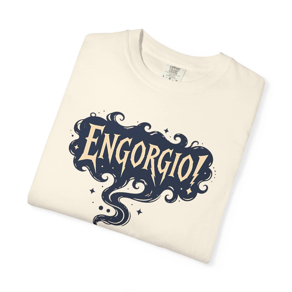 Folded cream-colored t-shirt showcasing the Engorgio magic wand and smoke graphic print.