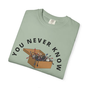 Folded green graphic t-shirt featuring box of random cables.
