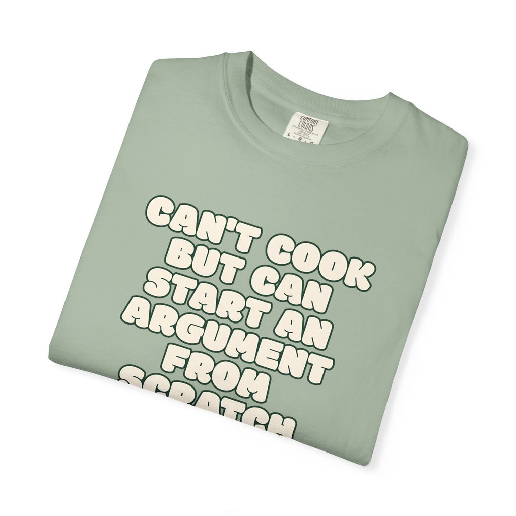 Folded green t-shirt featuring Can’t Cook slogan.