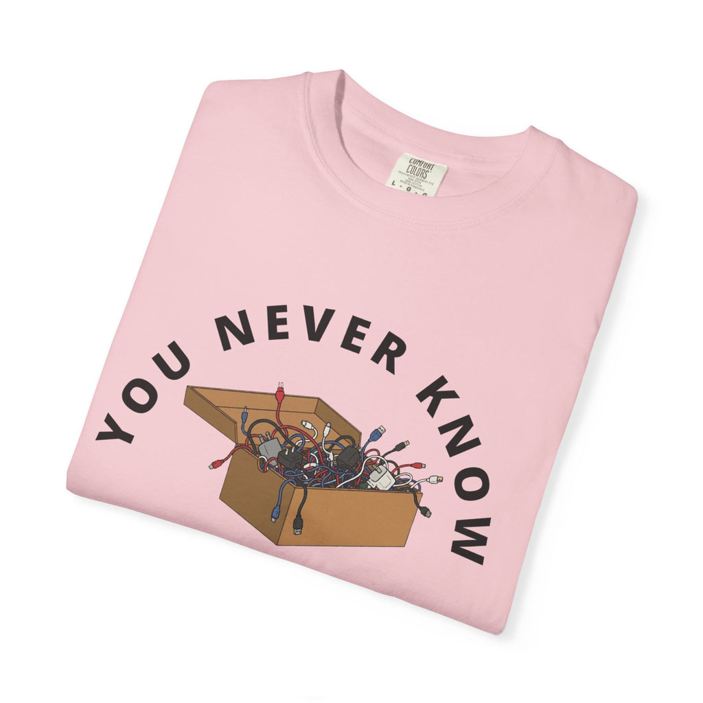 Folded pink graphic t-shirt featuring box of random cables.