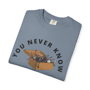 Folded ivory graphic t-shirt featuring box of random cables.