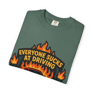 Folded t-shirt with retro badge design with Everyone Sucks At Driving But Me slogan