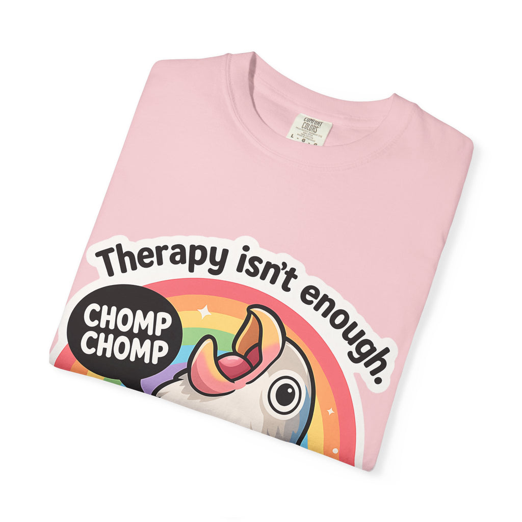 Neatly folded coral t-shirt showing the "Therapy isn't enough" graphic design.