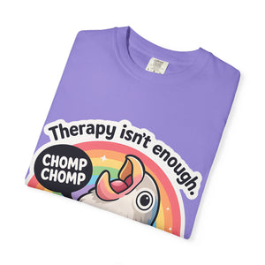 Neatly folded purple t-shirt showing the "Therapy isn't enough" graphic design.