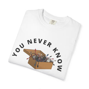 Folded white t-shirt featuring box of random cables.