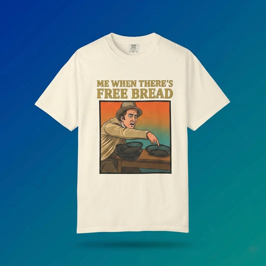 Ivory graphic t-shirt flat lay on blue background featuring Me When There’s Free Bread meme design. 