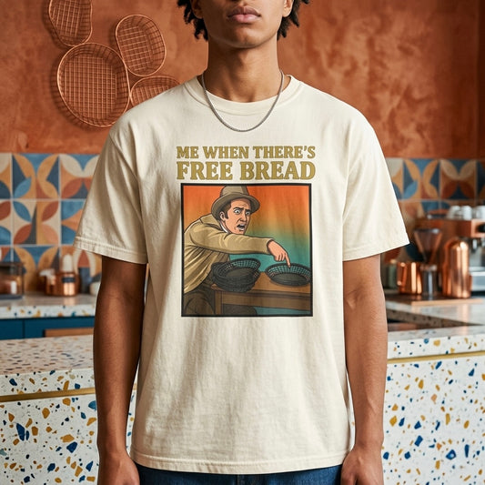 Ivory graphic t-shirt flat lay on blue background featuring Me When There’s Free Bread meme design. 