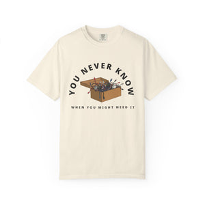 Flat lay of ivory  graphic t-shirt on white background featuring box of random cables.