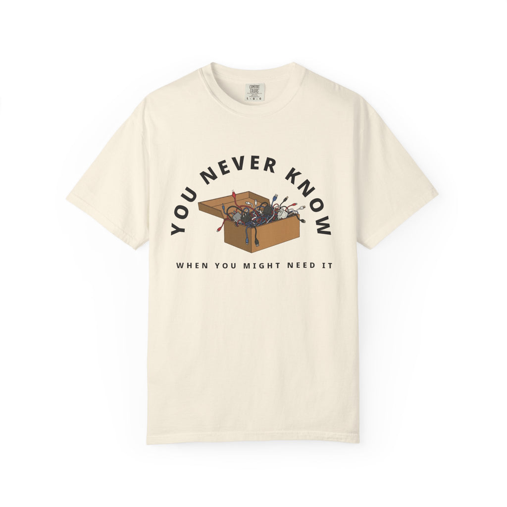 Flat lay of ivory  graphic t-shirt on white background featuring box of random cables.