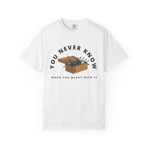Flat lay of white graphic t-shirt on white background featuring box of random cables and funny text.