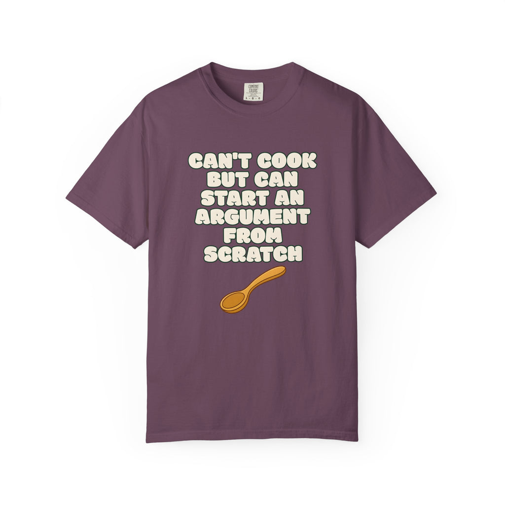 Flat lay of purple graphic t-shirt on white background featuring Can’t Cook slogan.