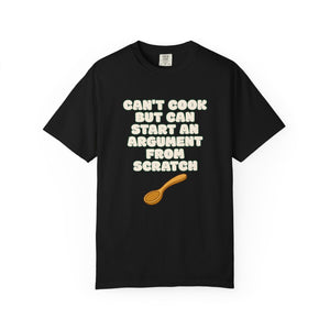 Flat lay of black graphic t-shirt on white background featuring Can’t Cook slogan.