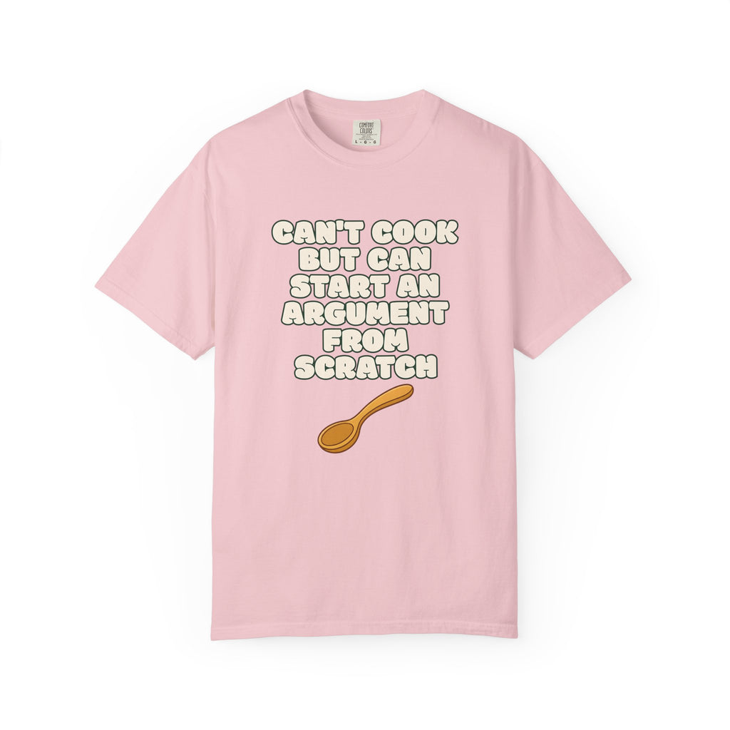 Flat lay of pink graphic t-shirt on white background featuring Can’t Cook slogan.