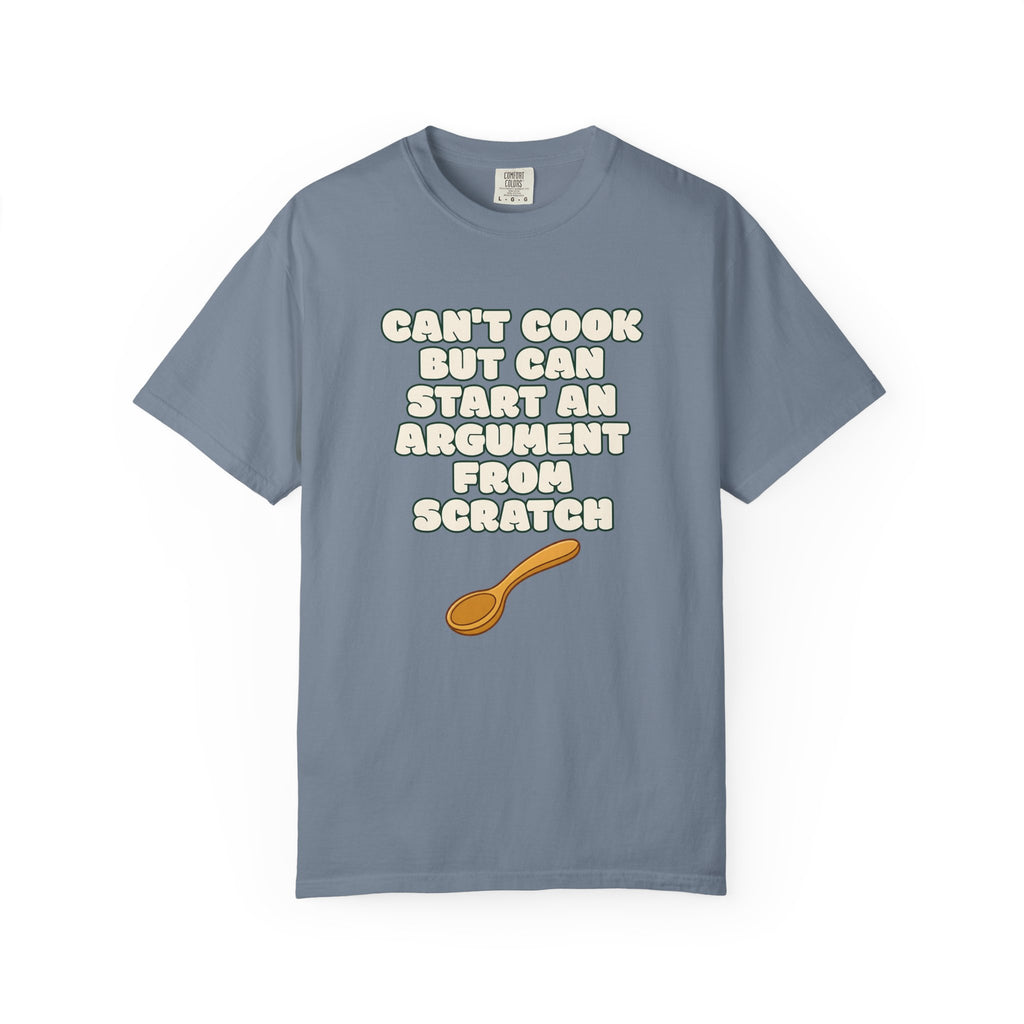 Flat lay of blue t-shirt on white background featuring Can’t Cook slogan.