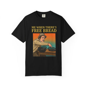 Flat lay of black graphic t-shirt on white background featuring Me When There’s Free Bread design.