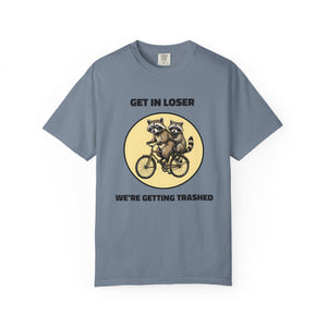 Flat lay of blue jean graphic t-shirt on white background featuring Get In Loser We’re Getting Trashed meme design.