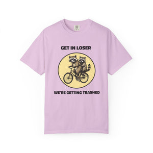 Flat lay of orchid graphic t-shirt on white background featuring Get In Loser We’re Getting Trashed meme design.