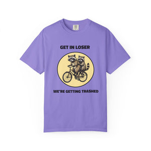 Flat lay of violet graphic t-shirt on white background featuring Get In Loser We’re Getting Trashed meme design.