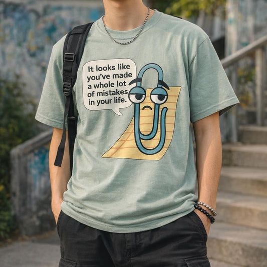 Green t-shirt featuring a cartoon paperclip with a sad face saying you made mistakes