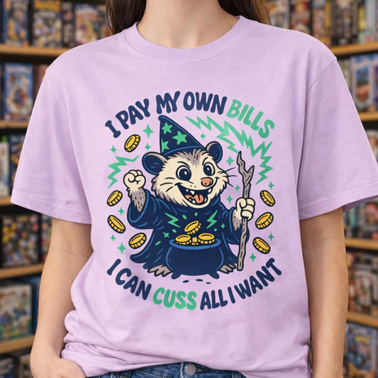 Pink t-shirt featuring a cartoon possum wizard holding a staff with funny text about paying bills