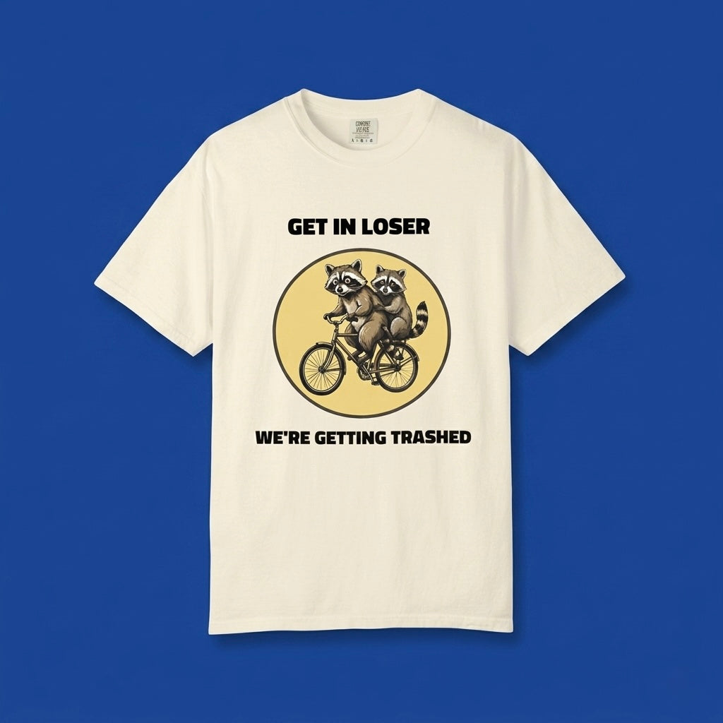 Ivory graphic t-shirt flat lay on blue background featuring Get In Loser We’re Getting Trashed meme design.