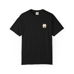 Flat lay of the front of a black t-shirt featuring a small minimalist drawing of a butt with radiating lines on the left chest.