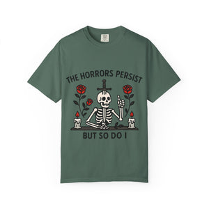 Flat lay of a moss green graphic tee featuring traditional tattoo style skeleton art.