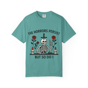Folded teal blue t-shirt with black text "The Horrors Persist".