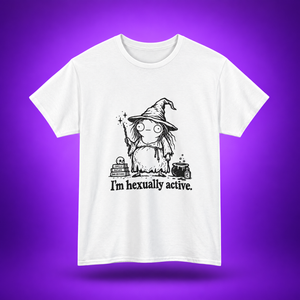 A white short-sleeve crewneck t-shirt featuring a black cartoon graphic of a witch with the text 'I'm hexually active.' printed on the front, set against a purple gradient background.
