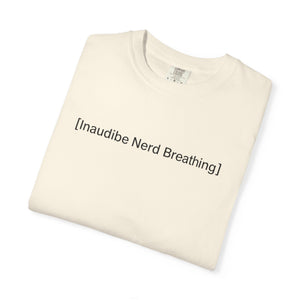 Folded cream-colored T-shirt with the text [Inaudible Nerd Breathing] printed in the center
