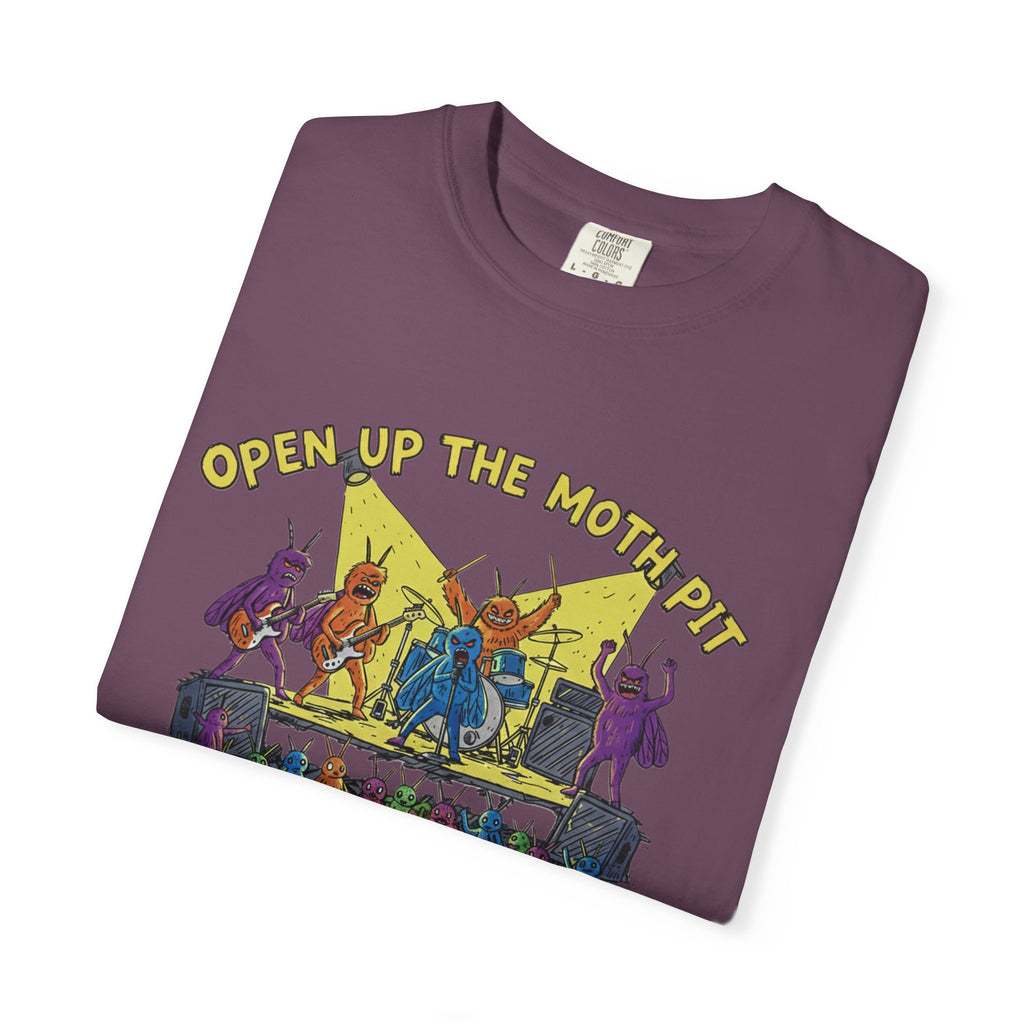 A plum purple Comfort Colors t-shirt neatly folded on a white background, showcasing the "Open Up The Moth Pit" graphic featuring a heavy metal band of colorful moths performing under a spotlight.