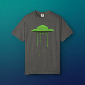 Neon Slime UFO tee centered against a vibrant teal and blue gradient background, showcasing the popping contrast of the slime alien graphic