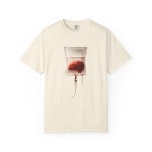 An off-white t-shirt displayed flat, showing a surreal graphic of a human brain in an IV drip bag