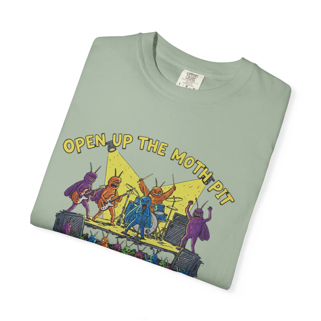 A sage green t-shirt neatly folded to showcase the "Open Up The Moth Pit" band graphic, featuring colorful moths on a stage with a lightbulb