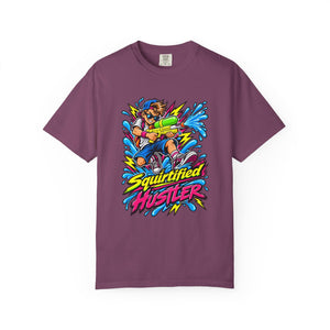 A short-sleeve crewneck t-shirt in a muted plum purple color, featuring a colorful graphic print of a cartoon character holding a water gun with the text 'Squirtified HUSTLER' in yellow and pink.