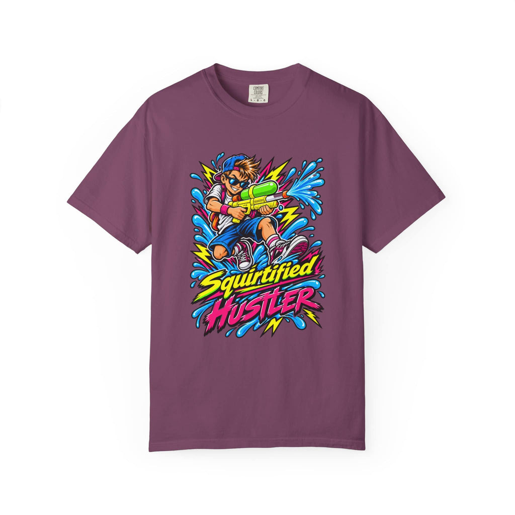 A short-sleeve crewneck t-shirt in a muted plum purple color, featuring a colorful graphic print of a cartoon character holding a water gun with the text 'Squirtified HUSTLER' in yellow and pink.