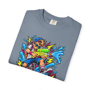 A folded slate blue crewneck t-shirt featuring a vibrant, colorful graphic of a cartoon boy holding a green and yellow water gun amidst splashing blue water and lightning bolts.