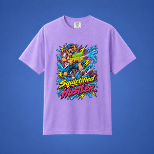 A light purple short-sleeve t-shirt with a colorful graphic of a cartoon character holding a green water hose, with the text 'Squirtified Hustler' in yellow and pink. The t-shirt is displayed against a solid blue background.